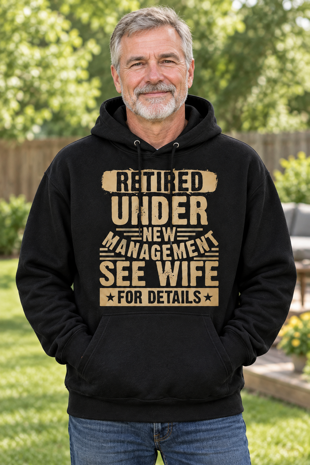 AI-generated model mockup of an older man wearing a black Retired Under New Management, See Wife for Details hoodie with tan lettering.